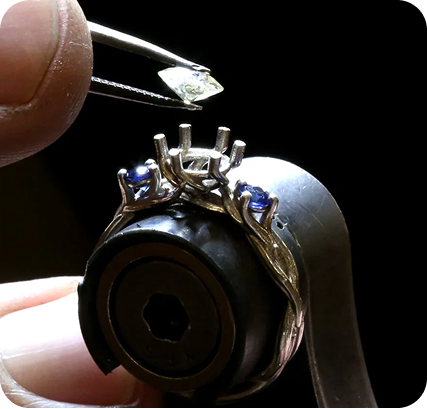 Jewellery setter positioning gemstones with precision tools